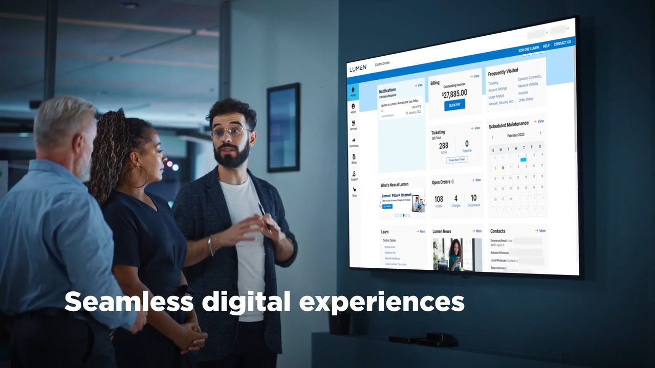 Three people in an office looking a a screen showing a portal